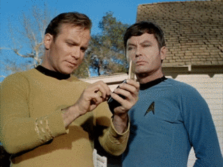 Kirk and McCoy try us use a tricorder.
